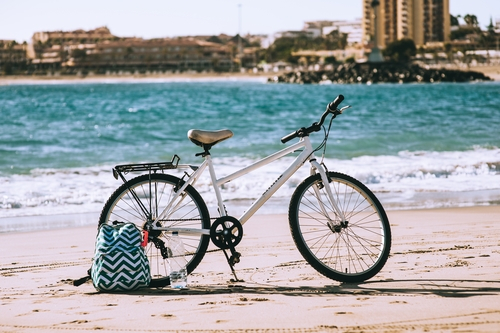 Fiets met tas op het strand