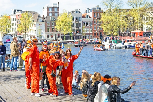 Mensen vieren Koningsdag in oranje aan het water