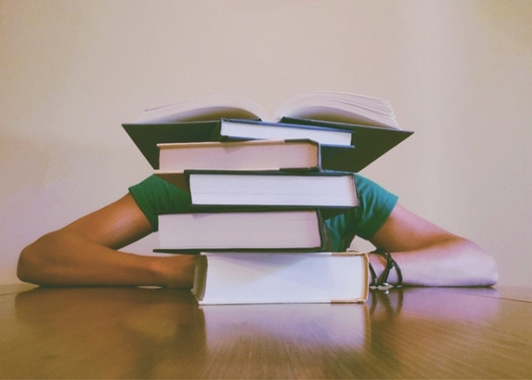 Student achter stapel boeken